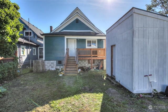 rear view of property featuring a lawn