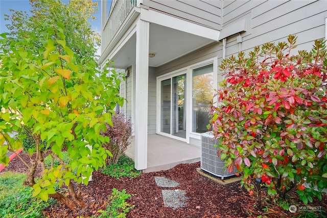 view of side of home with central AC unit and a balcony