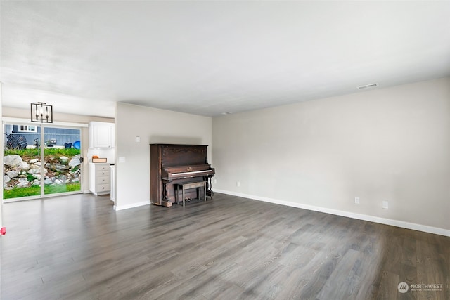 unfurnished living room featuring a notable chandelier and hardwood / wood-style flooring