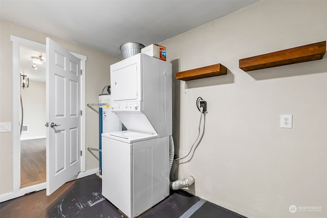 laundry area with stacked washer and clothes dryer and water heater