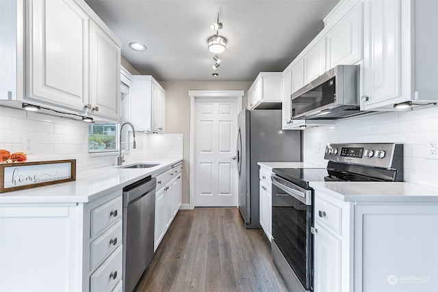 kitchen featuring dark wood-type flooring, sink, white cabinets, stainless steel appliances, and backsplash