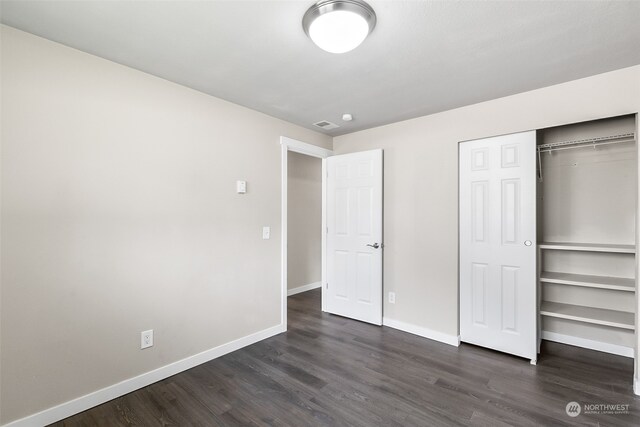 unfurnished bedroom featuring a closet and dark hardwood / wood-style floors