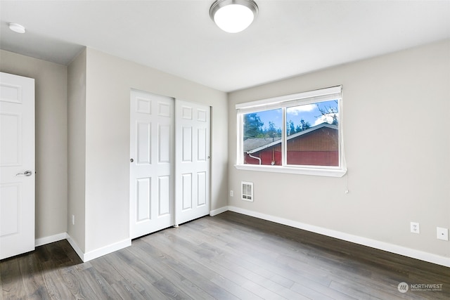 unfurnished bedroom with a closet and hardwood / wood-style floors