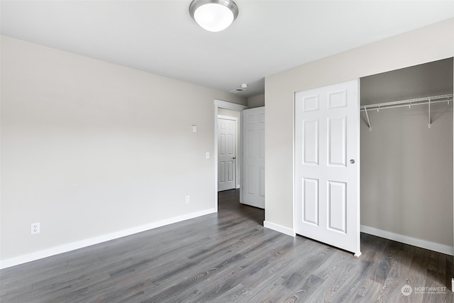 unfurnished bedroom featuring dark wood-type flooring and a closet