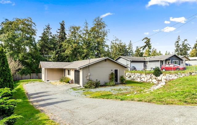 ranch-style house with a garage and a front lawn