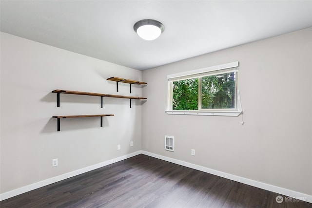 spare room with dark wood-type flooring