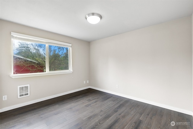 unfurnished room with dark wood-type flooring