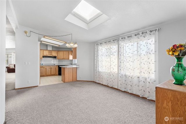 unfurnished living room featuring a chandelier, a skylight, light colored carpet, and sink