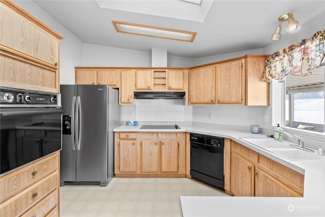 kitchen featuring vaulted ceiling, tasteful backsplash, light brown cabinets, black appliances, and sink