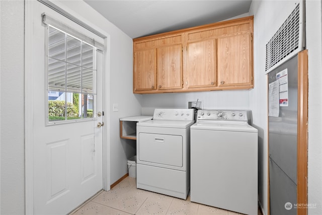 laundry room featuring cabinets, independent washer and dryer, and light tile patterned flooring