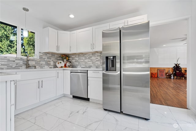 kitchen featuring white cabinets, decorative light fixtures, backsplash, and stainless steel fridge with ice dispenser