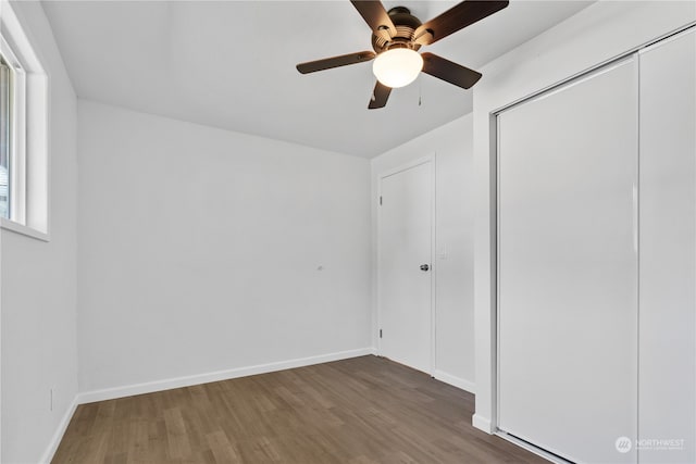 unfurnished bedroom featuring ceiling fan, a closet, and hardwood / wood-style floors