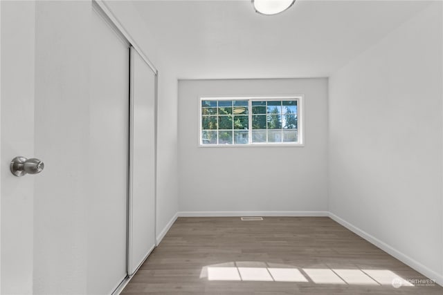 unfurnished bedroom with light hardwood / wood-style floors and a closet