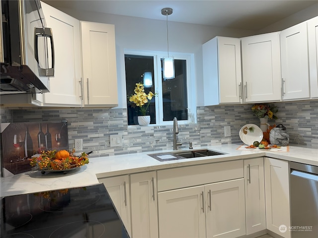 kitchen featuring stainless steel appliances, white cabinetry, sink, and backsplash