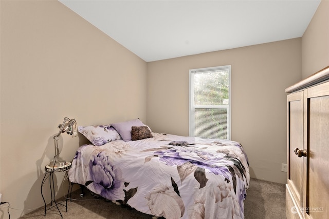 carpeted bedroom with lofted ceiling