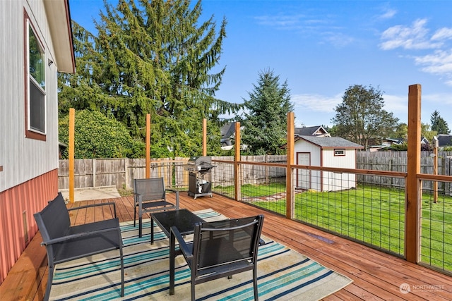 wooden terrace with area for grilling, a storage shed, and a yard