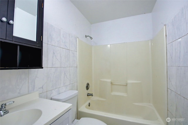 full bathroom with tub / shower combination, vanity, tile walls, and toilet