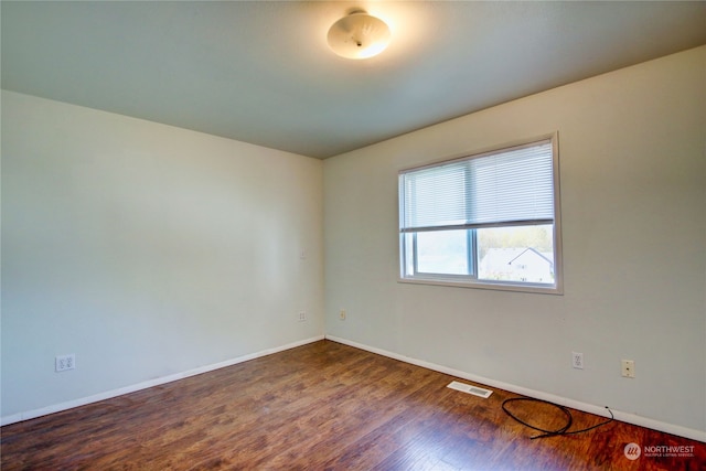 empty room with dark hardwood / wood-style flooring