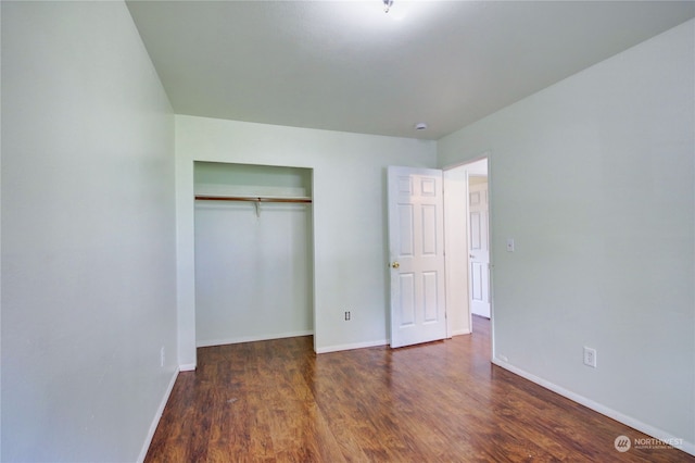 unfurnished bedroom featuring a closet and dark wood-type flooring