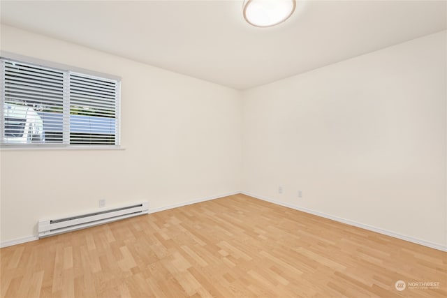 spare room with hardwood / wood-style flooring and a baseboard radiator