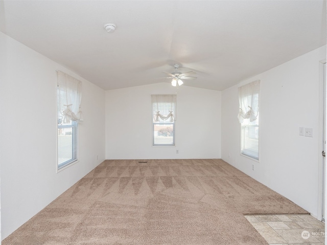 carpeted spare room featuring ceiling fan, plenty of natural light, and vaulted ceiling