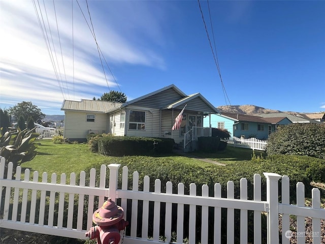 bungalow-style home with a front lawn and a fenced front yard
