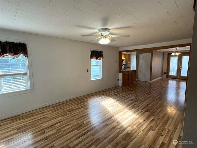 empty room with ceiling fan, a wealth of natural light, and hardwood / wood-style floors