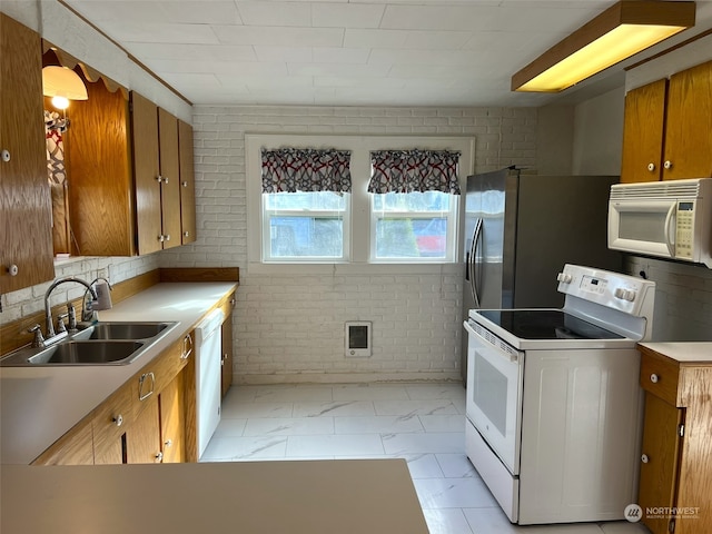 kitchen featuring white appliances, sink, brick wall, heating unit, and light tile patterned floors