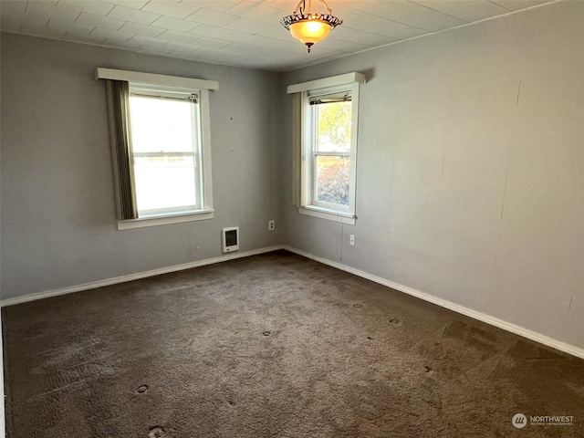 spare room with baseboards and carpet