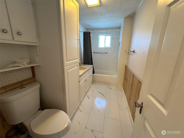 full bathroom featuring marble finish floor, toilet, vanity, and shower / tub combo with curtain