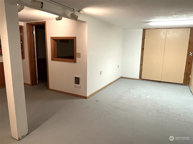 empty room with heating unit and a textured ceiling