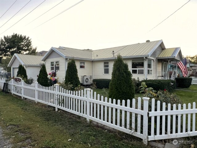 view of side of home with fence private yard, ac unit, and metal roof