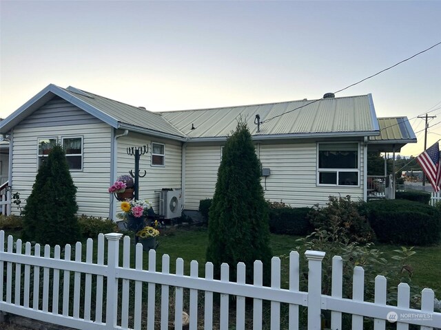 view of front of house with metal roof, ac unit, and a fenced front yard
