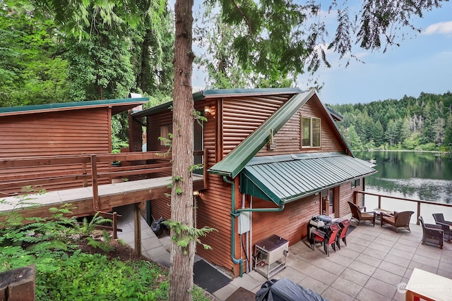 exterior space with a patio area and a deck with water view