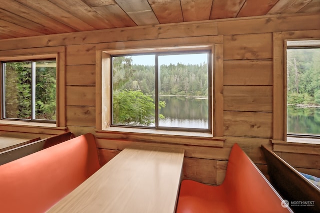 unfurnished sunroom with plenty of natural light, a water view, and wooden ceiling