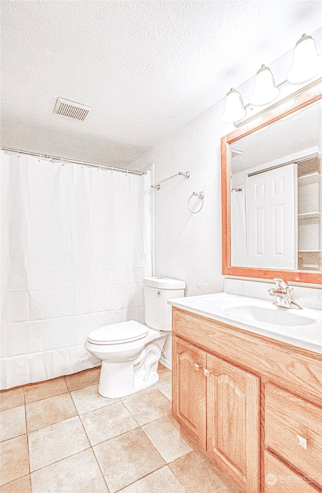 bathroom with vanity, tile patterned flooring, toilet, and a textured ceiling