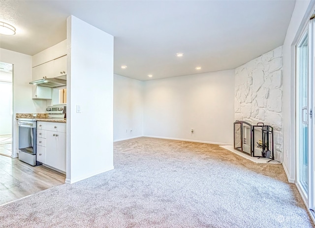 unfurnished living room with light carpet and a fireplace