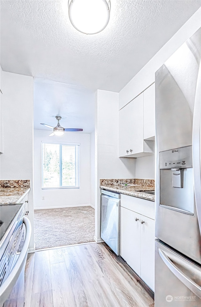 kitchen with ceiling fan, a textured ceiling, light hardwood / wood-style flooring, white cabinetry, and stainless steel appliances