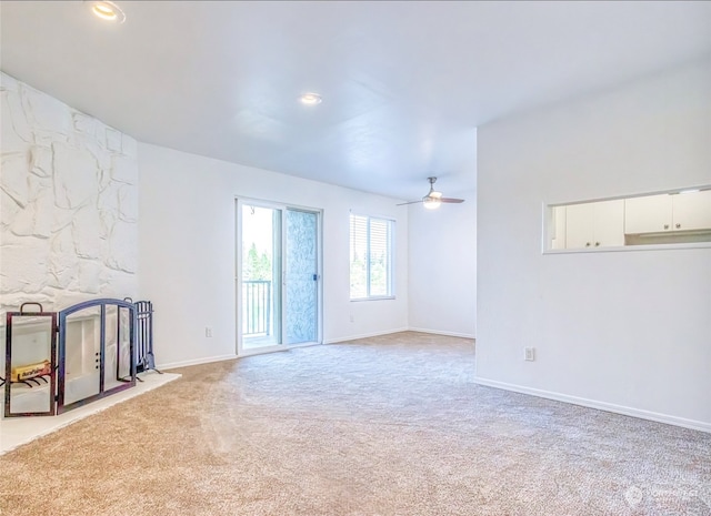 unfurnished living room featuring ceiling fan and light colored carpet