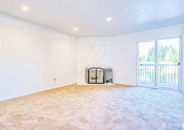 unfurnished living room featuring light colored carpet and a fireplace