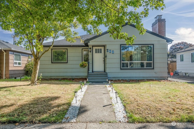 bungalow-style house with a front lawn