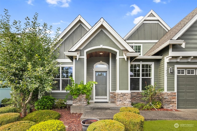 1925 32nd Avenue Ct SW, Puyallup, WA 98373 - view of exterior entry featuring board and batten siding, a garage, and stone siding