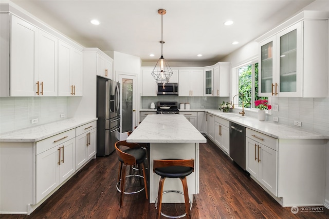 kitchen featuring stainless steel appliances, dark hardwood / wood-style flooring, white cabinetry, and a kitchen island