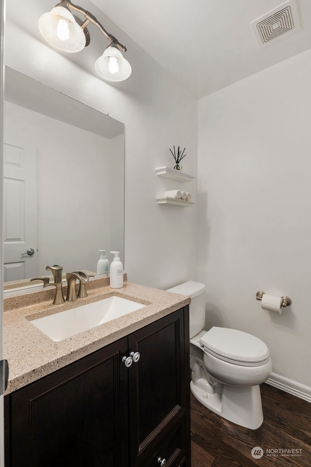 1925 32nd Avenue Ct SW, Puyallup, WA 98373 - half bathroom with visible vents, baseboards, toilet, vanity, and wood finished floors