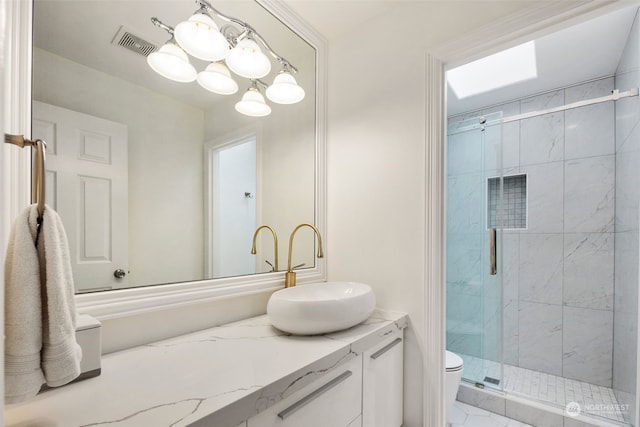 bathroom featuring a shower with shower door, vanity, and toilet