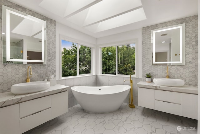 bathroom with a bath, tile patterned flooring, and vanity