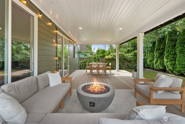 wooden deck with an outdoor living space with a fire pit