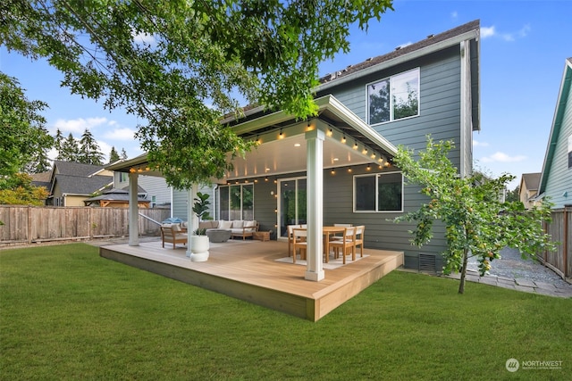 back of property featuring outdoor lounge area, a deck, and a yard