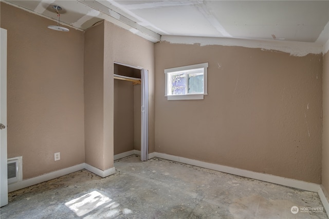 unfurnished bedroom featuring vaulted ceiling and a closet