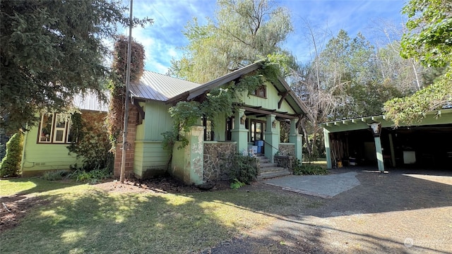 view of front of home featuring a front lawn, a carport, and a porch